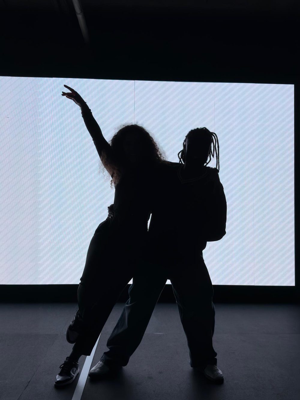 Par a dançar kizomba em silhueta contra o ecrã do estúdio